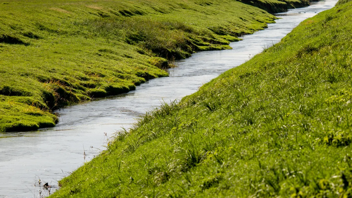 How to Design Dry Creek Beds That Handle Storm Water Grass-lined drainage swale with flowing water