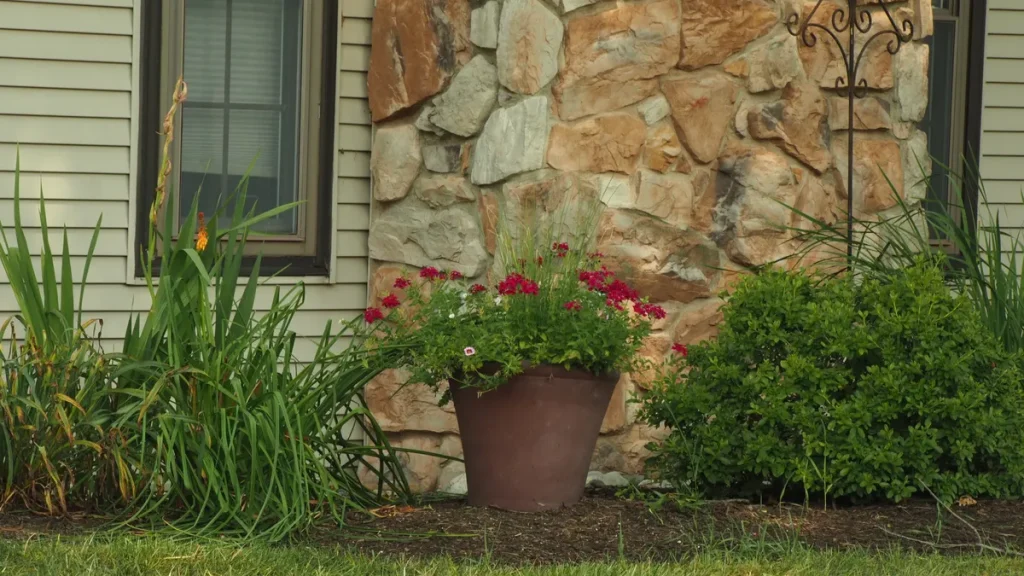 House exterior with foundation planting bed and potted flowers